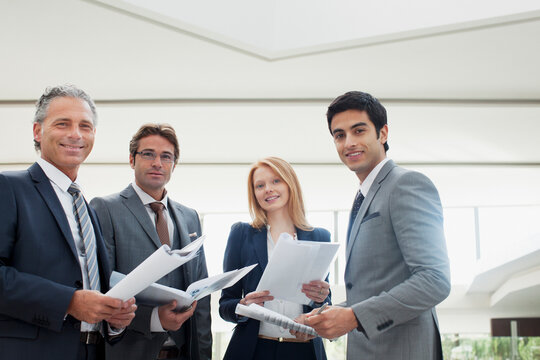 Portrait of smiling business people reviewing paperwork
