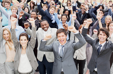 Portrait of business people cheering with arms raised in crowd