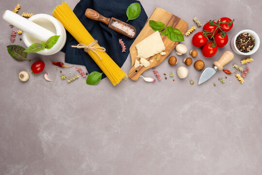Raw ingredients for italian pasta and vegan sauce:spaghetti,parmesan cheese,fresh basil,mushrooms,dried oregano,tomatoes,garlic,pink sea salt and dried pepper.Top view,copy space for your text.
