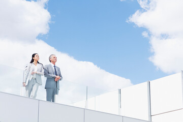 Businessman and businesswoman on balcony