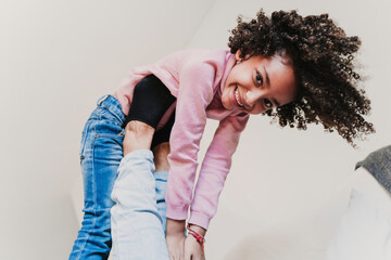 Portrait of happy little girl playing with her mother at home