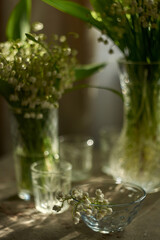 
beautiful composition with lilies of the valley and glass vases