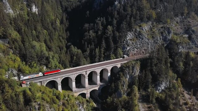 Aerial view of freight train rides on Krauselklause Viaduct on historical Semmering mountain railway (Semmeringbahn), Lower Austria.