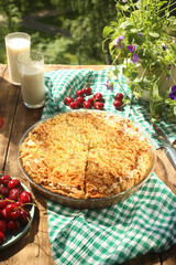 Pie with strawberries and cherries, cherries, with a glass of milk
