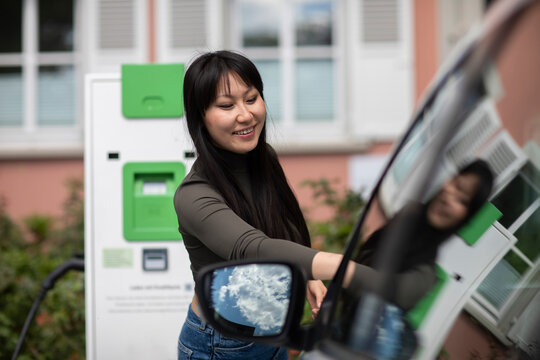 Carsharing, woman renting an electric car