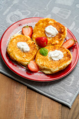 Obraz na płótnie Canvas cheesecakes with raspberry and sour cream on a plate