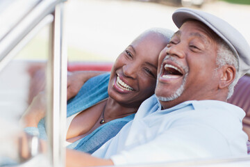 Smiling couple laughing in car