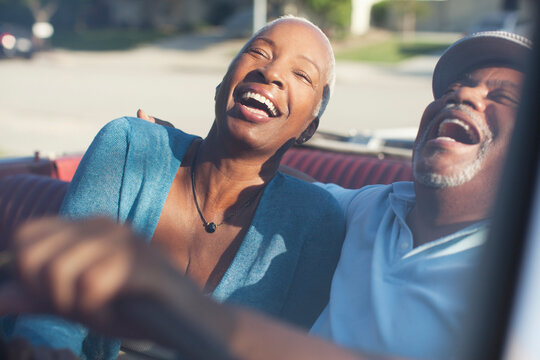 Older couple laughing in convertible