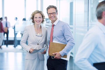 Business people smiling in office hallway