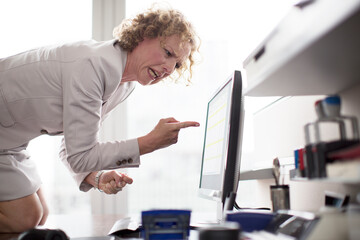 Businesswoman yelling at computer in office
