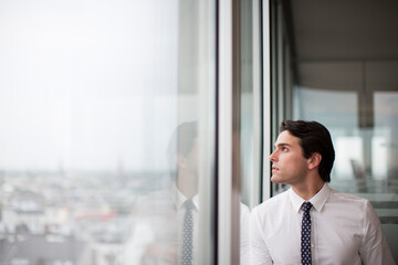 Businessman looking out office window