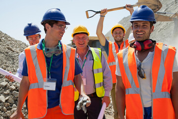 Workers smiling together in quarry - obrazy, fototapety, plakaty