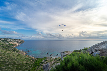 Fototapeta na wymiar Beautiful panoramic landscape in Mirador de sa Torre, Majorca. Cliff coastal area with several coves, and a paraglider on the background.