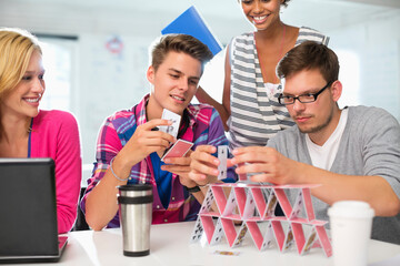 Business people making house of cards in office