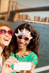 Women in novelty sunglasses taking picture by city cityscape