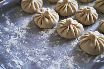 Pile of homemade raw khinkali delicious Georgian dumplings on home kitchen table