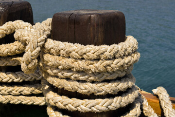 Fototapeta na wymiar mooring rope superimposed on a wooden bollard