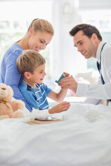 Doctor giving son asthma inhaler