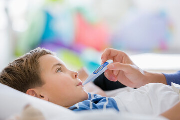 Mother taking son's temperature