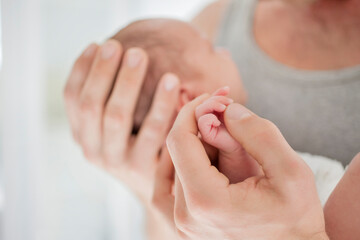 Fototapeta na wymiar Mother cradling newborn baby's hand