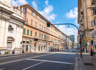 Fototapeta na wymiar Genoa, Italy - August 18, 2019: Via XX Setembre, the main boulevard in Genoa with its arcades, beautiful buildings and a wide variety of modern shops
