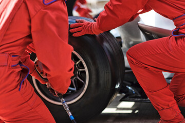 Racing team working at pit stop - obrazy, fototapety, plakaty