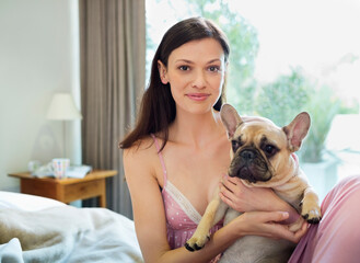 Woman petting dog in bed