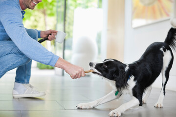 Man playing with dog in kitchen