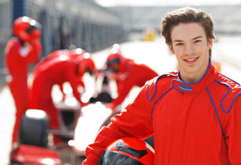 Racer holding helmet on track