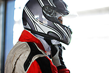 Racer tying on helmet in garage