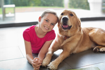 Smiling girl relaxing with dog indoors