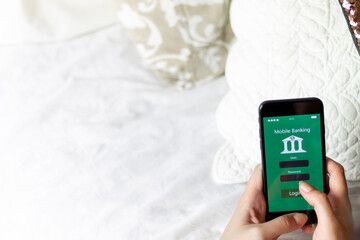 Young Woman using mobile banking app in her quiet room, zenithal plane, concept of using the bank whenever you want with copyspace, fintech and young people in finance