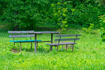 Old and dilapidated benches and table in an abandoned park