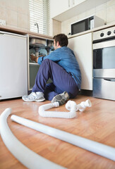 Plumber working on pipes under sink