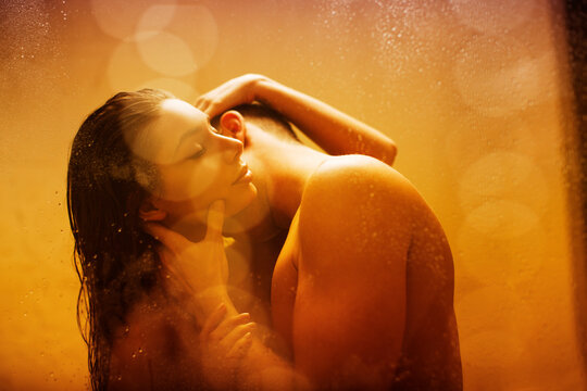 Nude couple kissing in shower