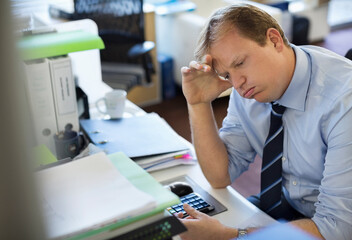 Businessman sighing at desk
