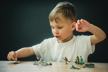 little child plays soldiers at the table