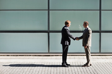 Businessmen shaking hands outdoors