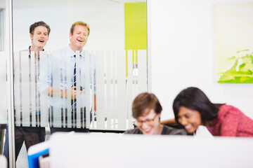 Businessmen eavesdropping on colleagues