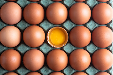 Chicken eggs broken in the middle of other eggs. Top view