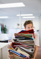 Businessman balancing folders in office - obrazy, fototapety, plakaty
