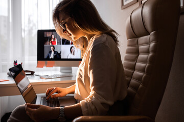 Beautiful business woman working on laptop while business conference at home. 