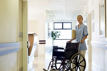 Nurse pushing wheelchair in hospital hallway