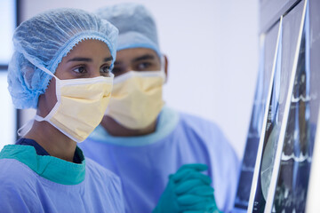 Surgeons examining x-rays in hospital room