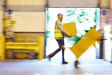 Blurred view of workers carrying boxes in warehouse