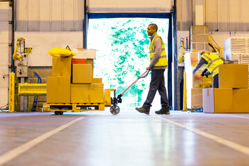 Worker carting boxes in warehouse - obrazy, fototapety, plakaty