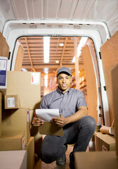 Delivery boy checking boxes in van