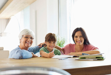 Obraz premium Three generations of women doing homework
