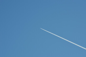 passenger aircraft vapor trail on blue summer sky