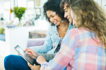 Fototapeta premium Friends using tablet computer on sofa